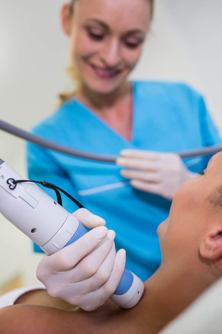 Woman receiving laser epilation treatment on her neck at beauty salon